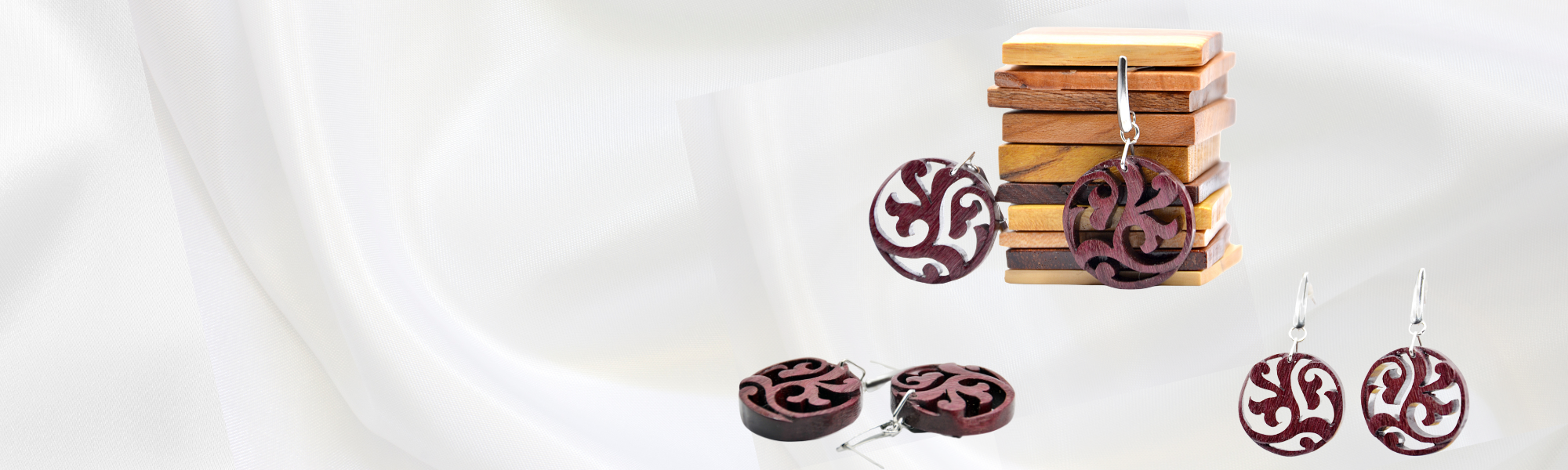 Création Artisanale de Bijoux Boucles d’oreilles artisanales en bois d’amarante violet, sculptées avec un motif inspiré du mouvement spiralé d’une plante.