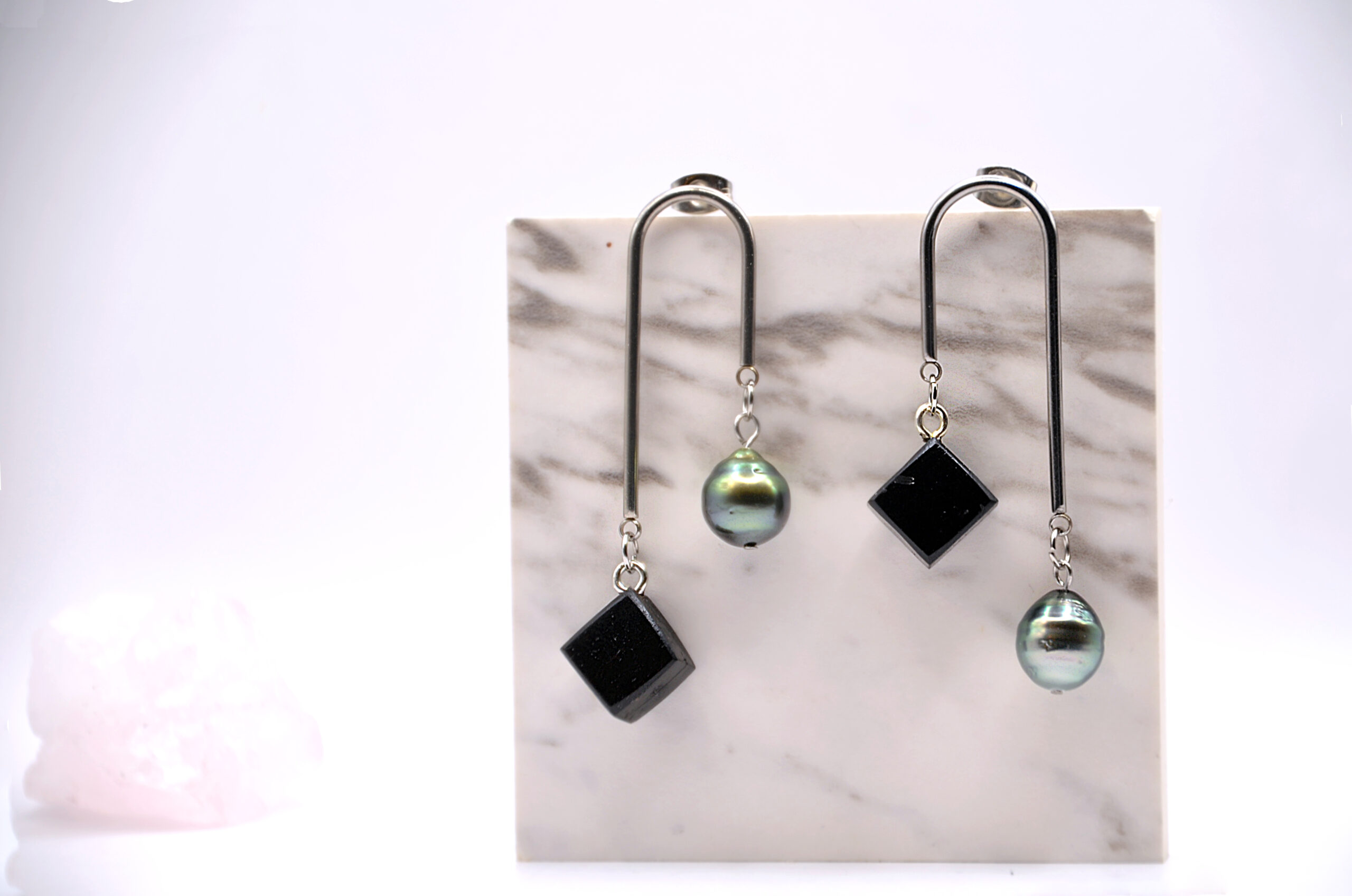 Boucles d’oreilles artisanales à motif en forme d’arche, associant une perle ronde de Tahiti et un élément carré en bois d’ébène noir.