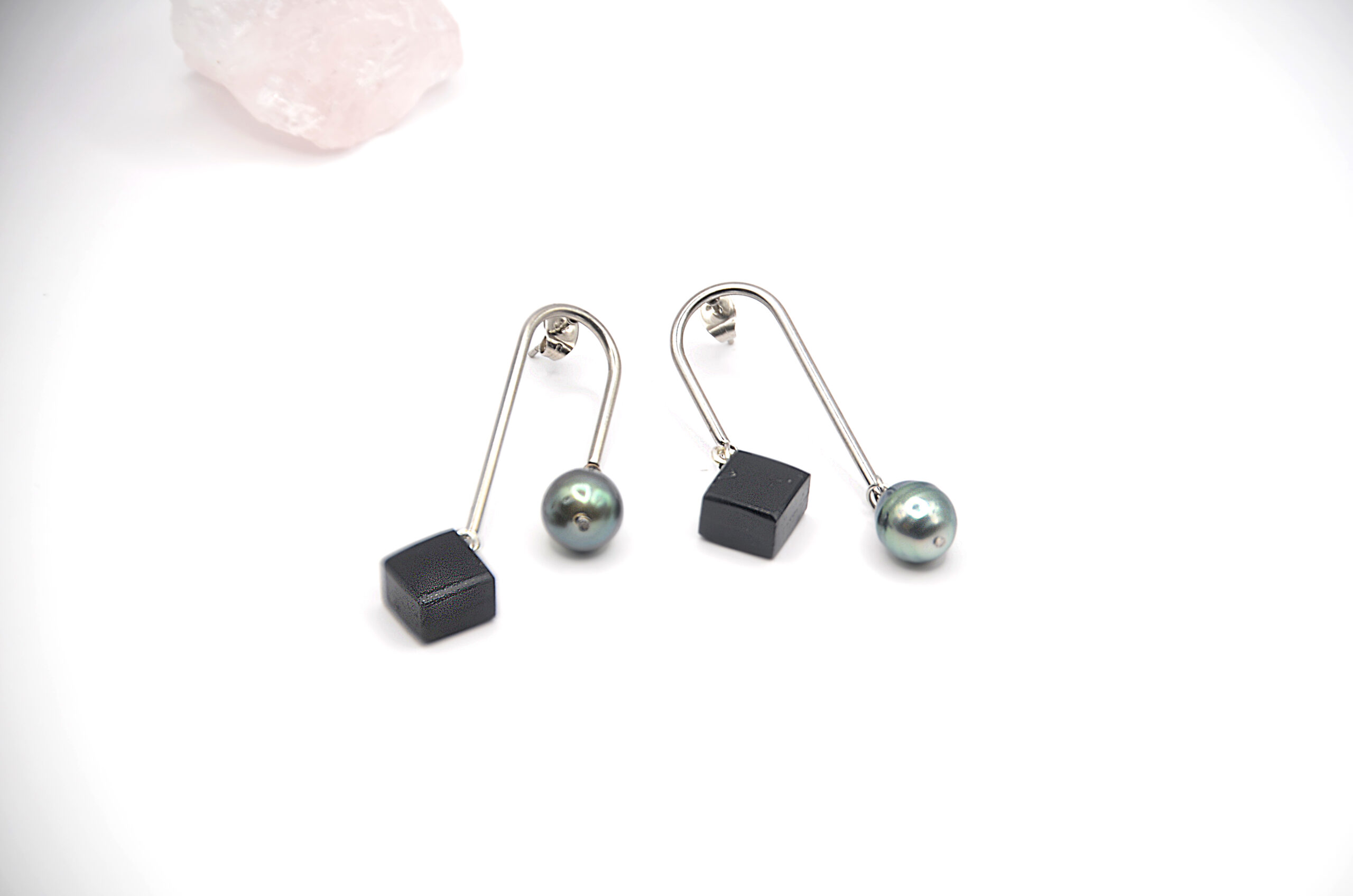 Création Artisanale de Bijoux Boucles d’oreilles artisanales à motif en forme d’arche, associant une perle ronde de Tahiti et un élément carré en bois d’ébène noir.