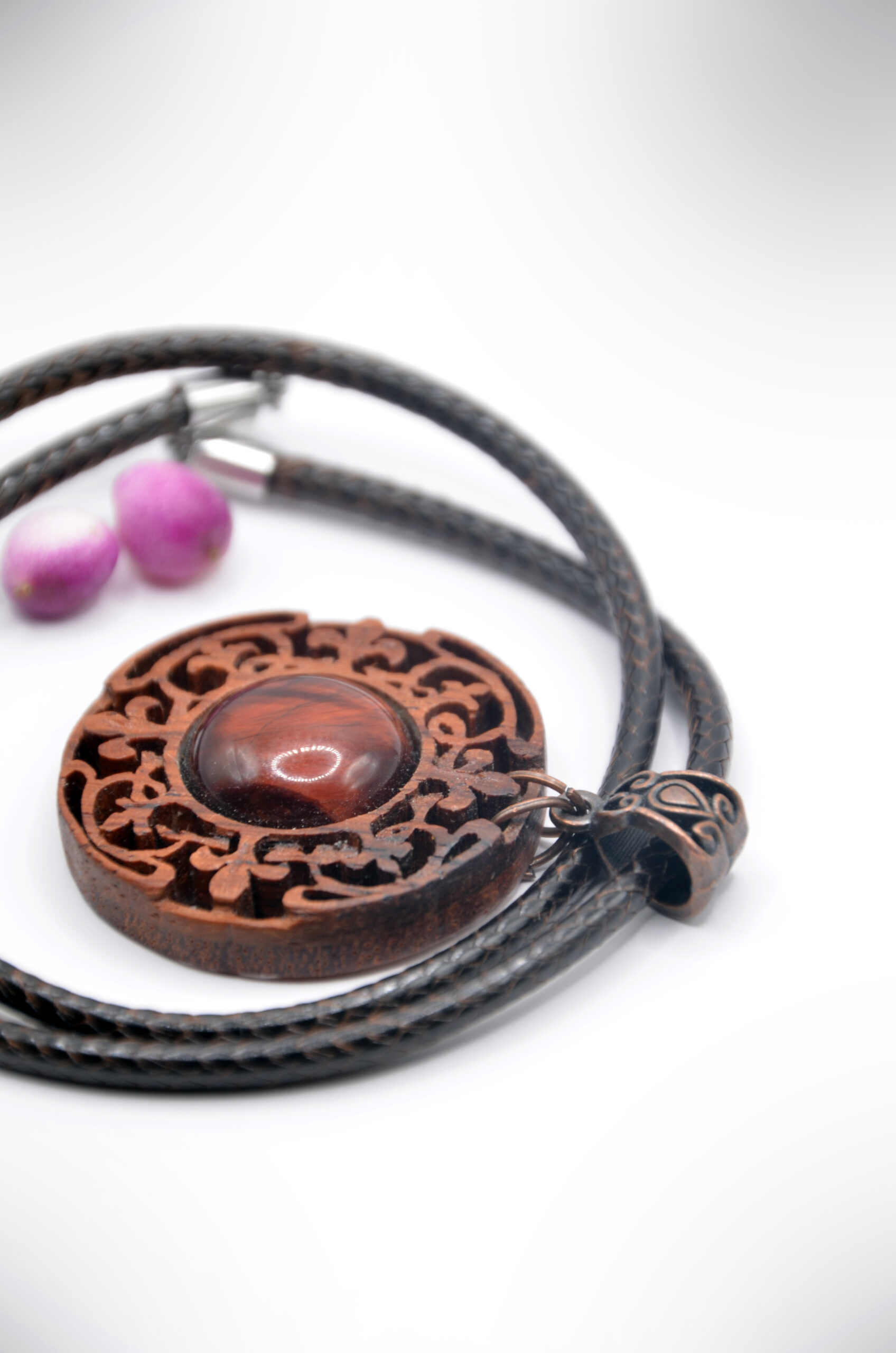 Collier artisanal en bois brun avec une pierre d’agate, sculpté selon un motif inspiré du mandala.