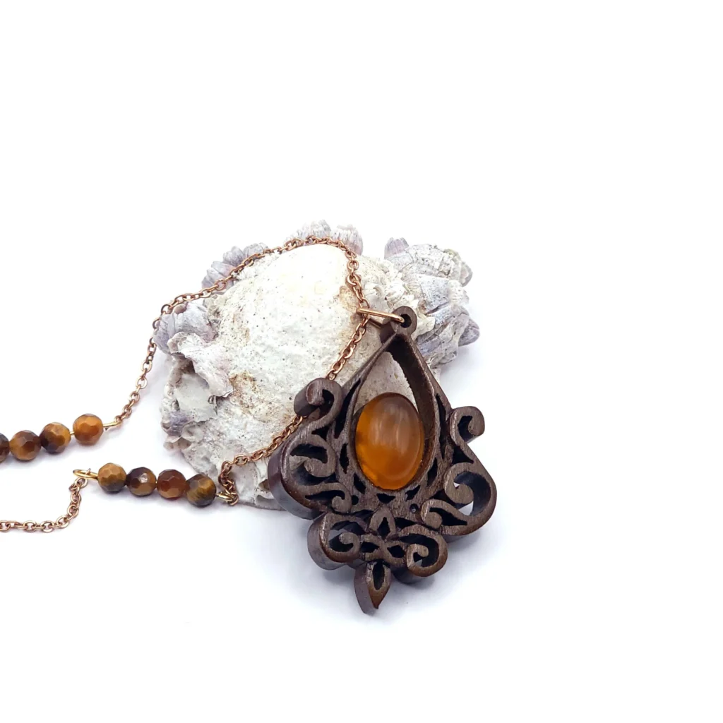 Collier artisanal en bois avec une pierre d’agate jaune, décoré d’un motif classique.