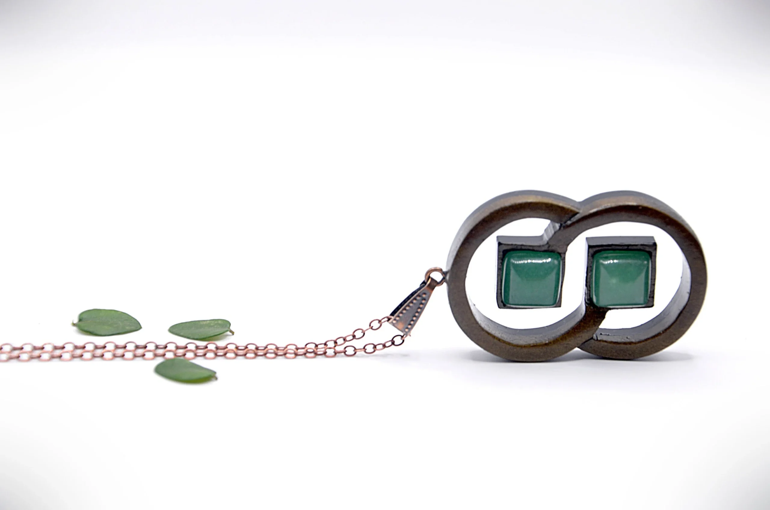 Collier artisanal en bois avec motif de deux anneaux entrelacés, associé à une pierre de jade vert.