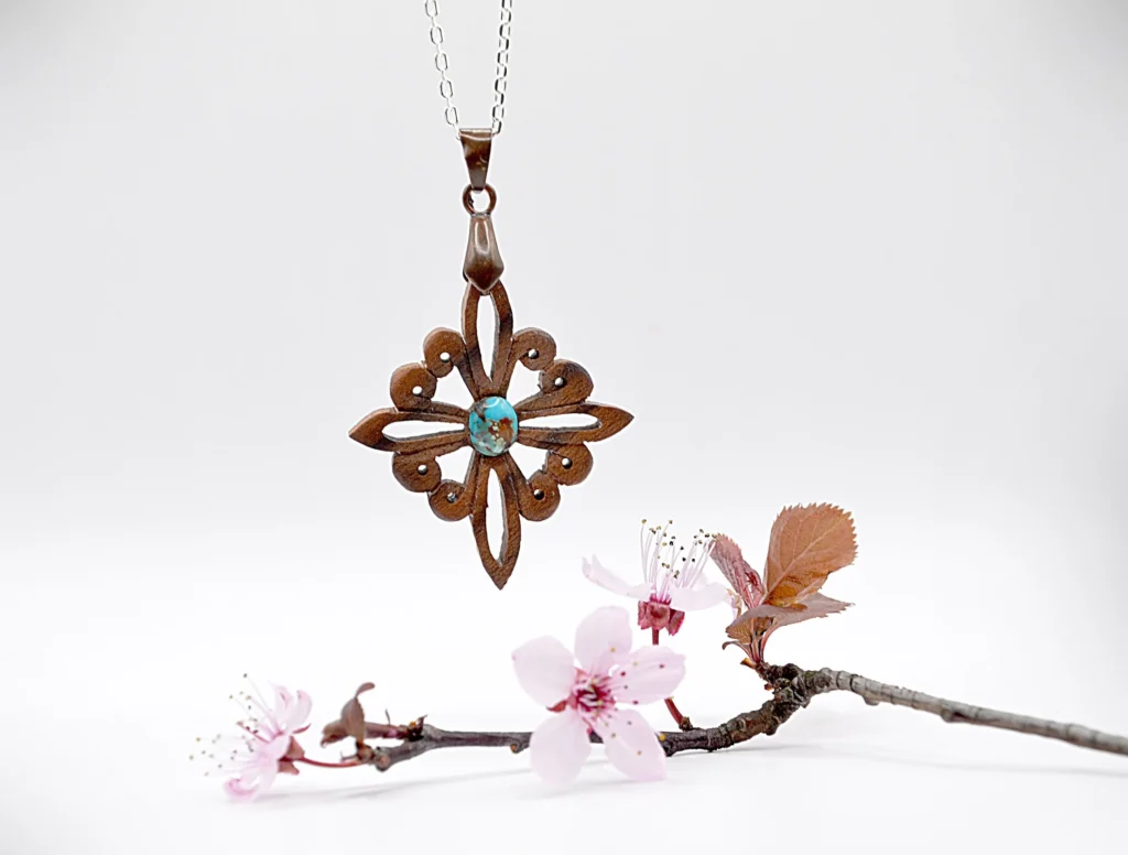 Collier artisanal en bois de noyer et pierre de turquoise, inspiré des motifs du site antique de Doura-Europos à l’époque parthe.