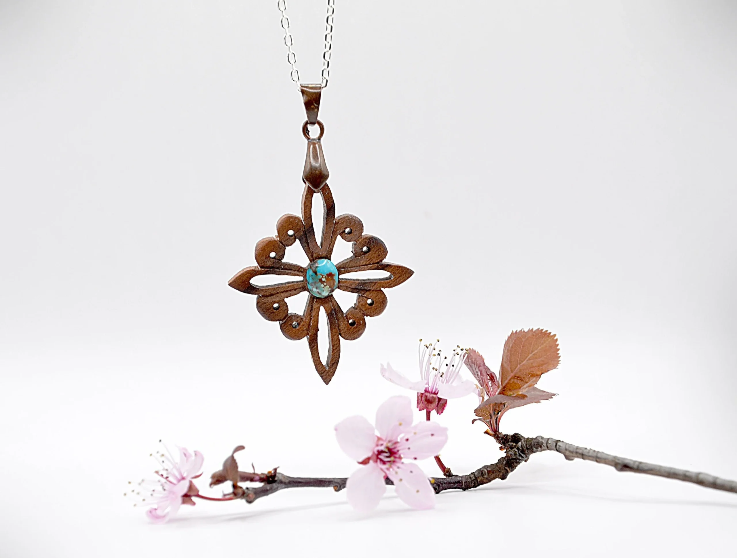 Collier artisanal en bois de noyer et pierre de turquoise, inspiré des motifs du site antique de Doura-Europos à l’époque parthe.