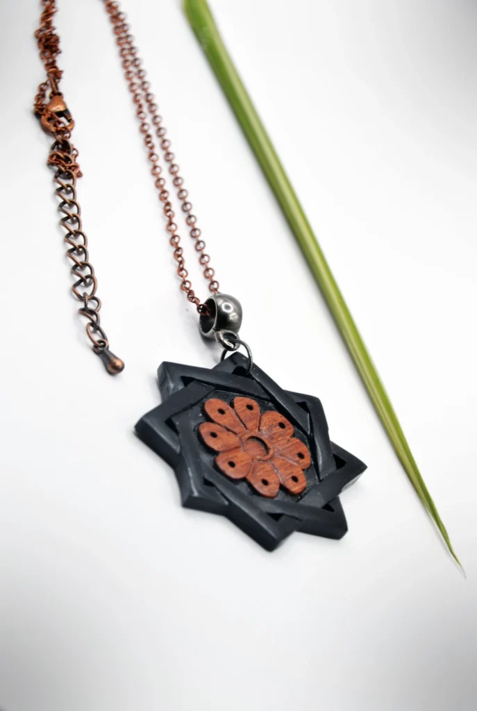 Collier artisanal inspiré de motifs sassanides de Taq-e Bostan, réalisé en marqueterie avec deux bois contrastés rouge et noir.